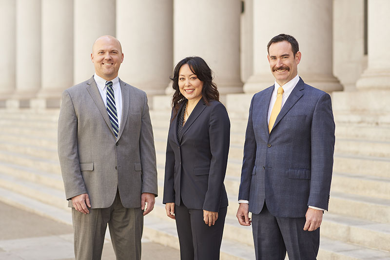 Family Attorneys Kimberly Lewellen, Michael Strebe, and Jason Hopper pose on the court steps